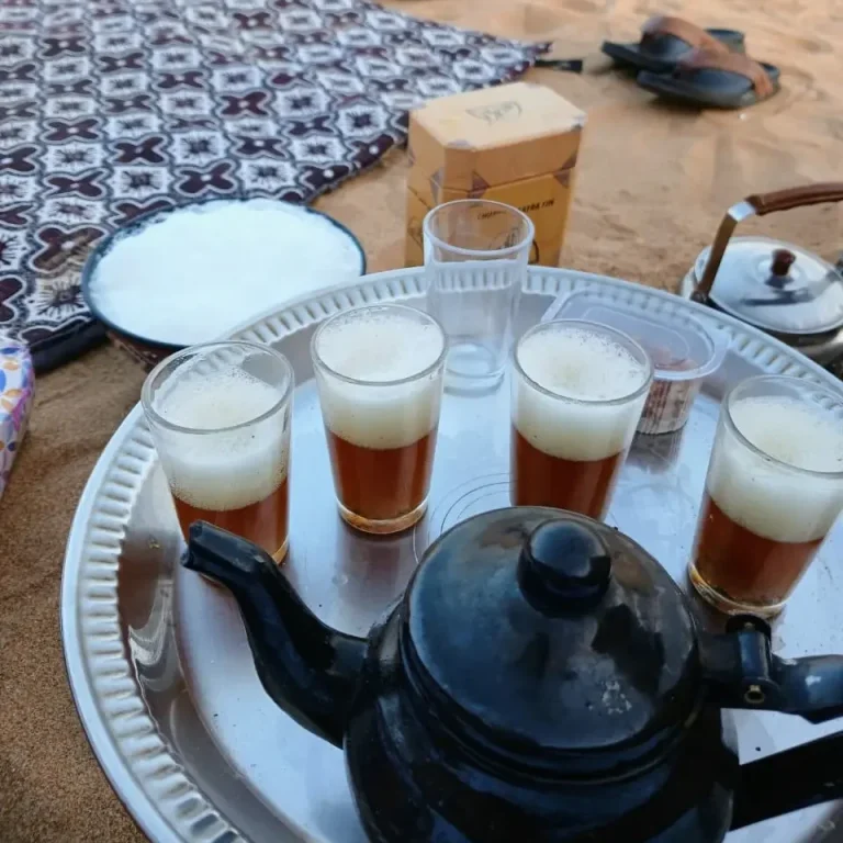 Té en el desierto del Sáhara Occidental Bandeja con tetera y vasos de té servidos sobre la arena durante una parada en el desierto del Sáhara Occidental.